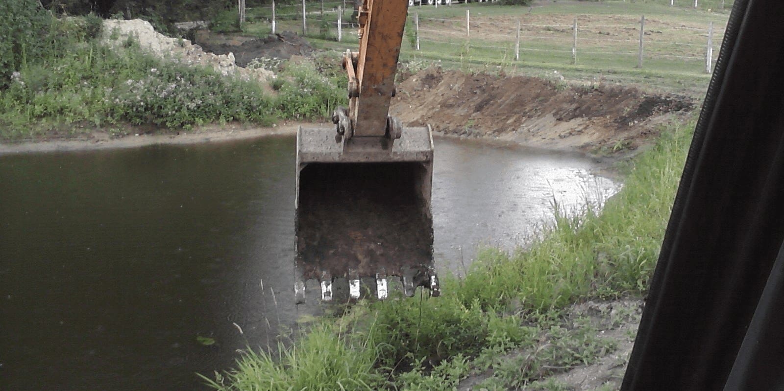 A large excavator is in the water.