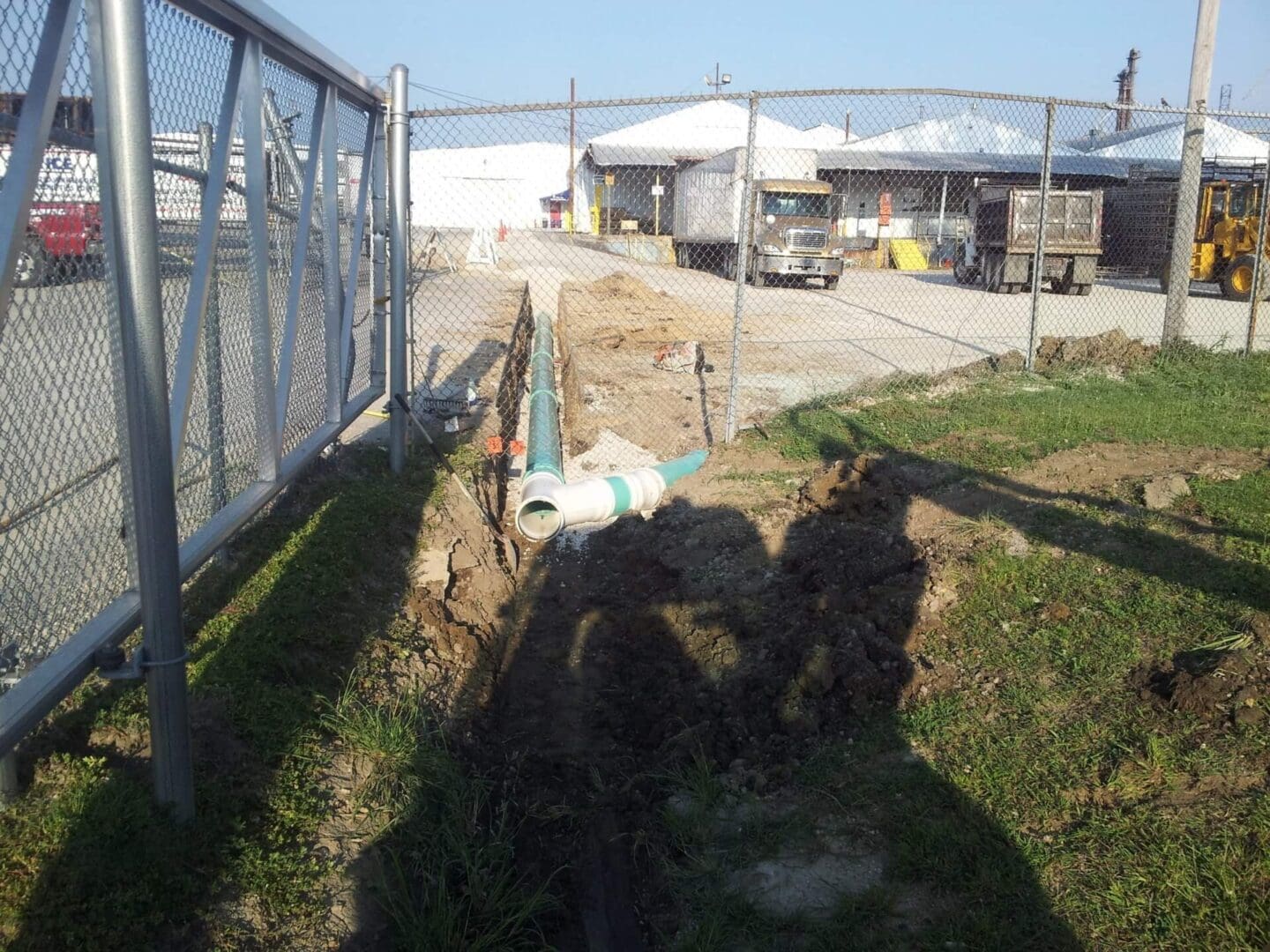 A view of a construction site with a fence and dirt.