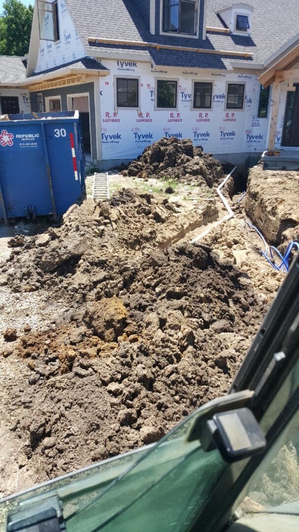 A pile of dirt in front of a dumpster.