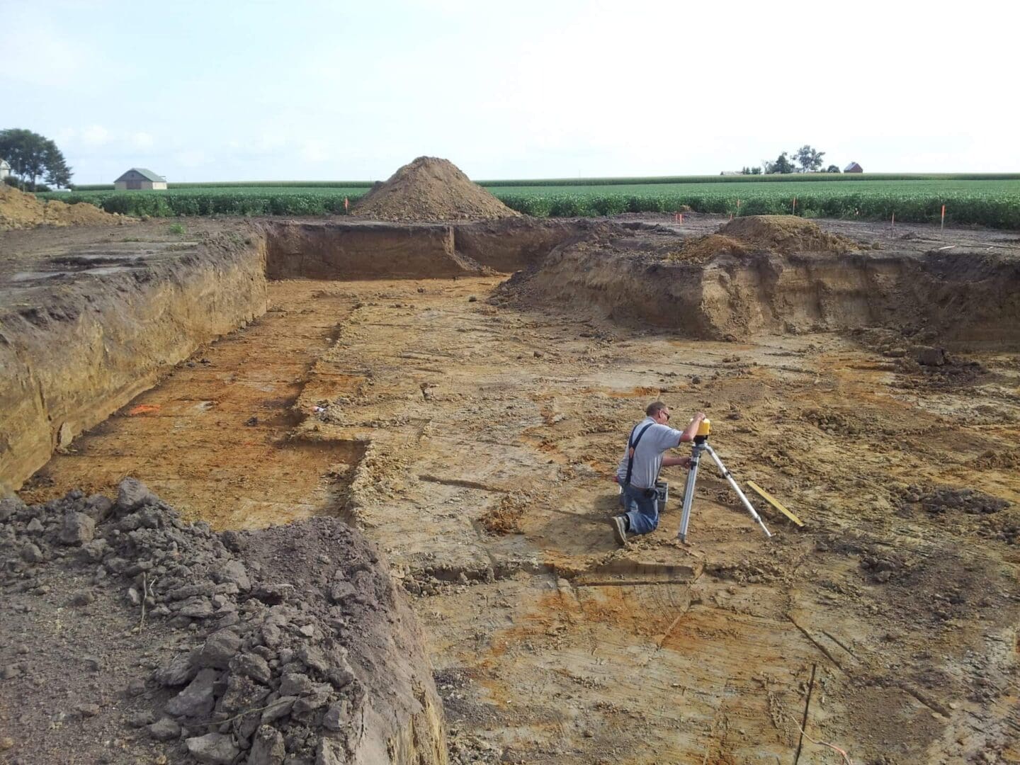 A man standing on top of a dirt hill.