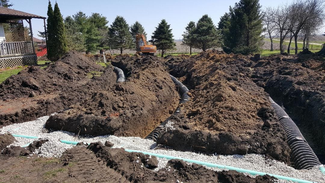 A tractor is digging in the dirt on a hill.