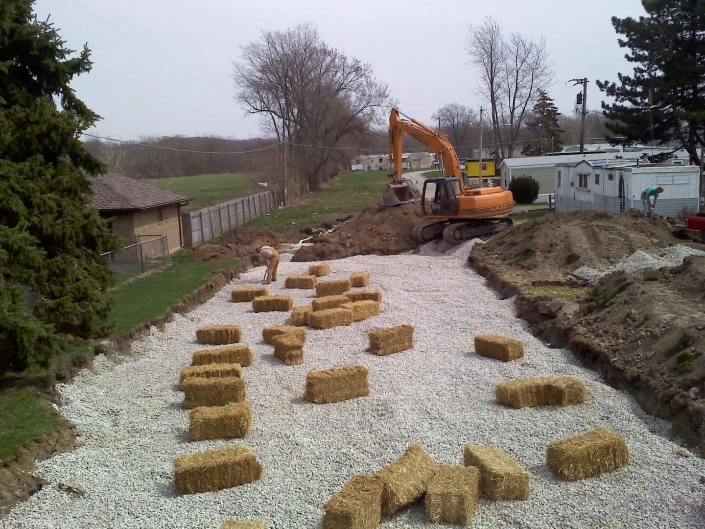 A tractor is digging through the ground to fill it with hay.