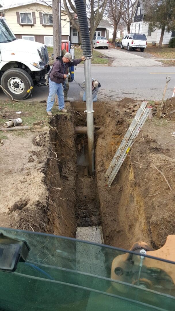 A man standing next to a pipe in the ground.